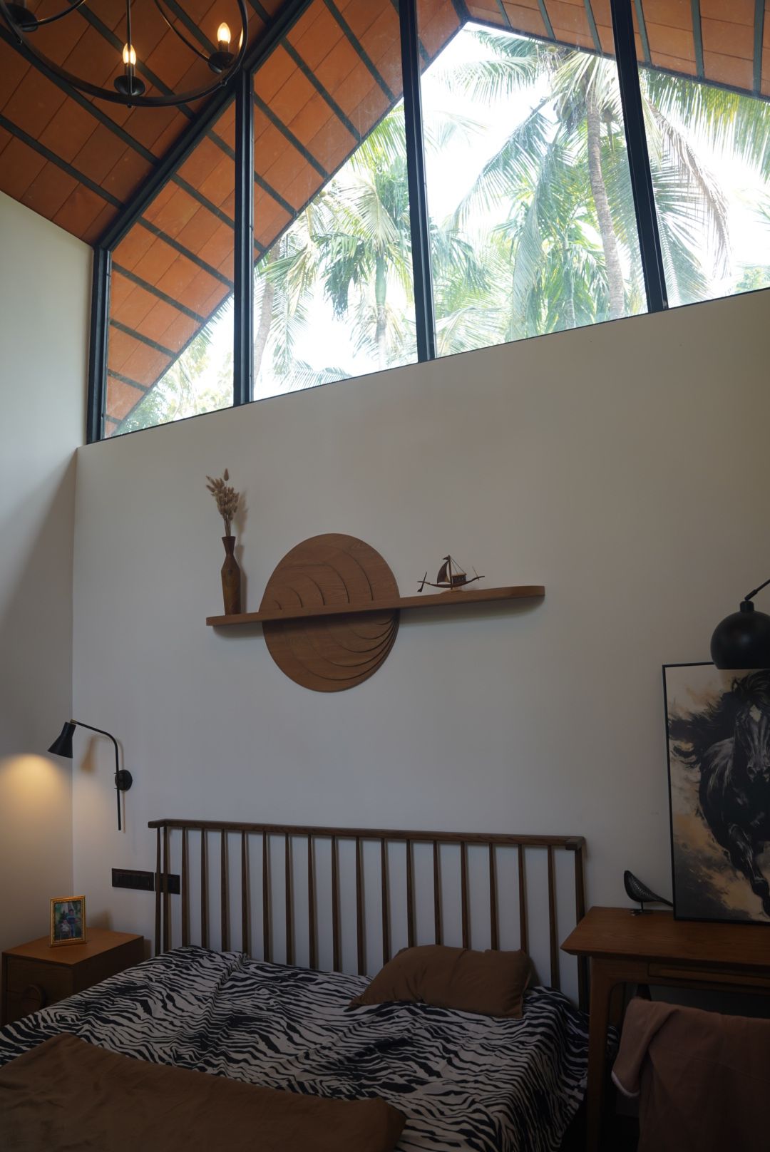Bedroom under tall clerestory windows looking out to coconut palms